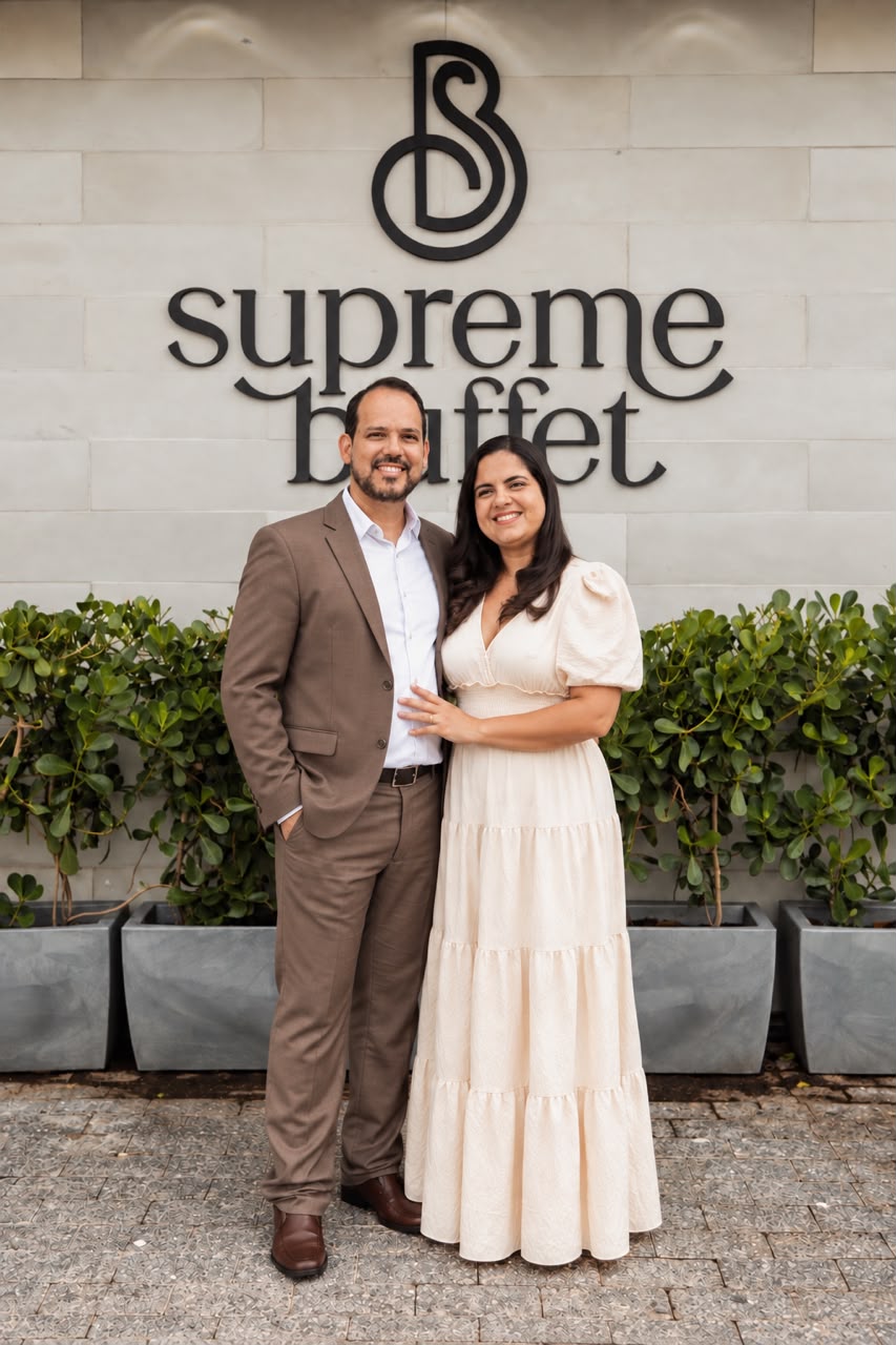 Júnior e Simone em frente ao símbolo do Supreme Buffet