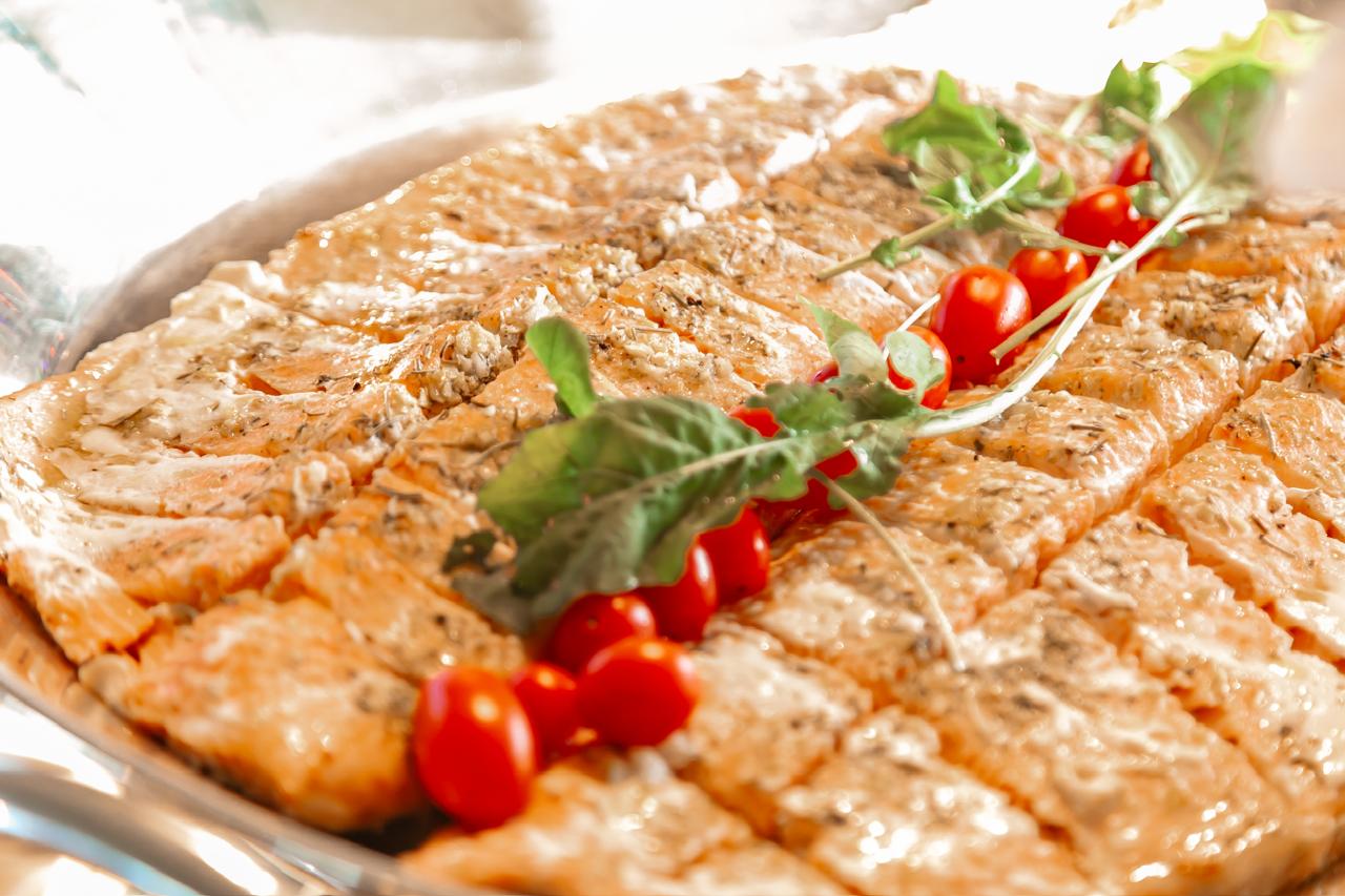 Salmão completo e bem apresentado em uma elegante travessa de prata